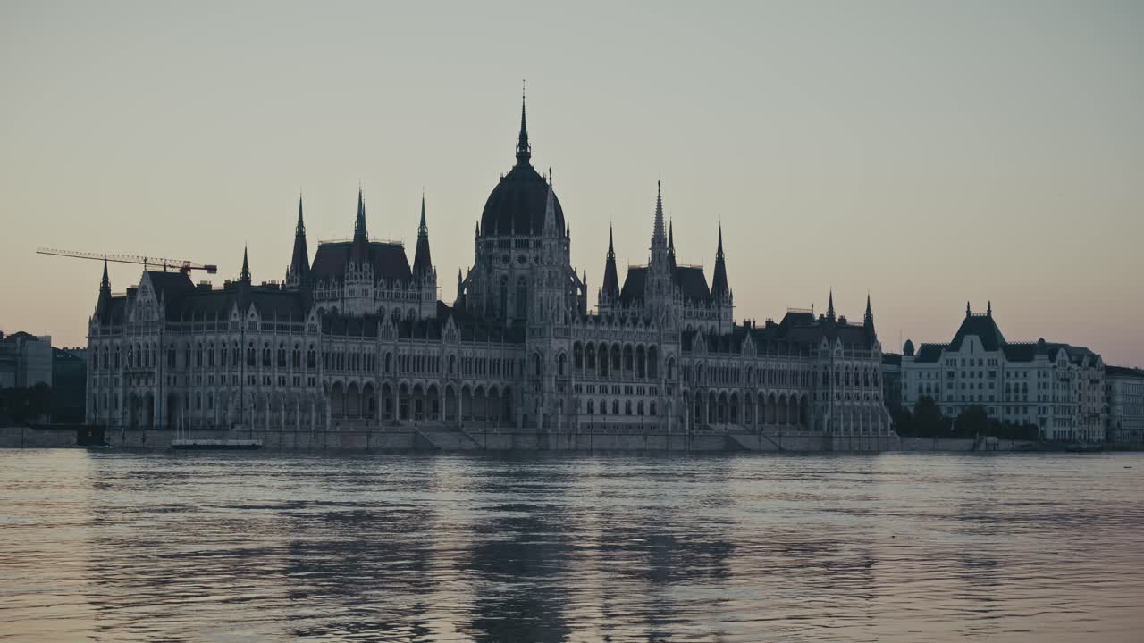 L'edificio del Parlamento di Budapest si riflette su un fiume calmo, in piena e in aumento all'alba
