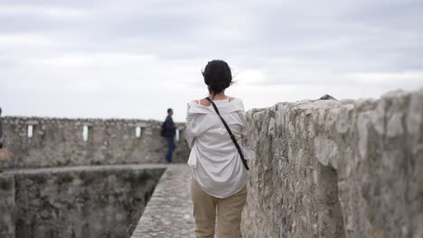 menina andando na velha fortaleza na frança