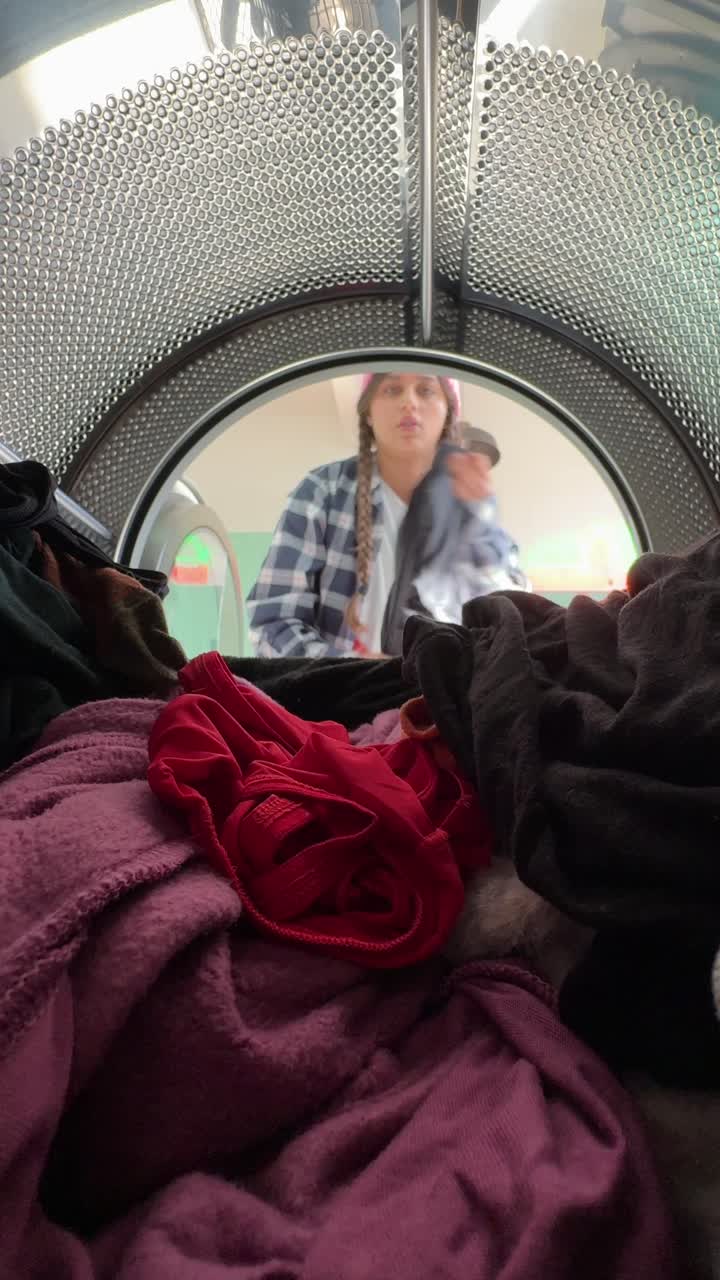 persona cargando la ropa en una lavadora