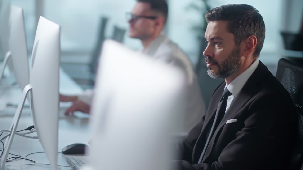retrato de empresario adulto en una oficina de espacio abierto trabajando en una computadora de cubierta. hombre profesional escribiendo en el teclado de la pc. retrato de hombre de negocios positivo mirando la pantalla de la computadora en el interior