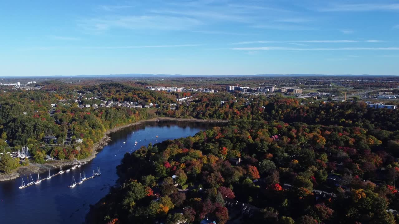 Experience the breathtaking beauty of Qu&eacute;bec in autumn as a drone soars over a serene river, capturing stunning aerial views