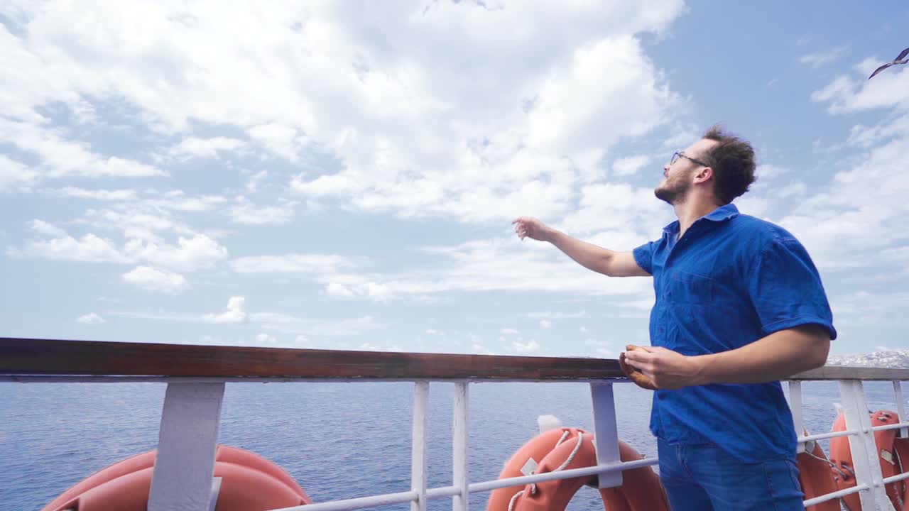Man throwing bagels to seagulls from ferry in slow motion.