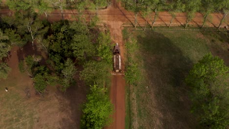 Aerial,-water-sprinkler-old-truck,-moistening-town-street-in-Argentina