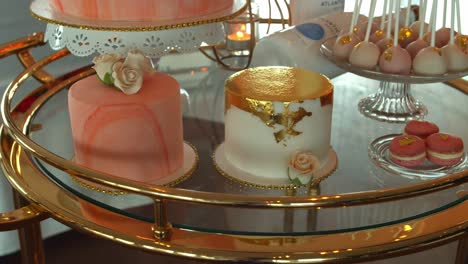 Glass-table-full-of-weddings-sweets-and-cake,-close-up-motion-shot