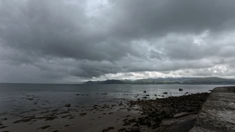 threatening timelapse storm clouds speeding over snowdonia mountain range and irish seascape