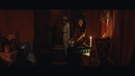 a man in hat checks the inside of the gypsy circus cart