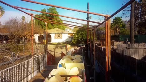 antena sobre los carros oxidados de una montaña rusa de carnaval abandonada