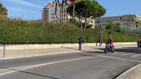 santa claus de la ciudad de cascais montando una moto con una bolsa de regalos