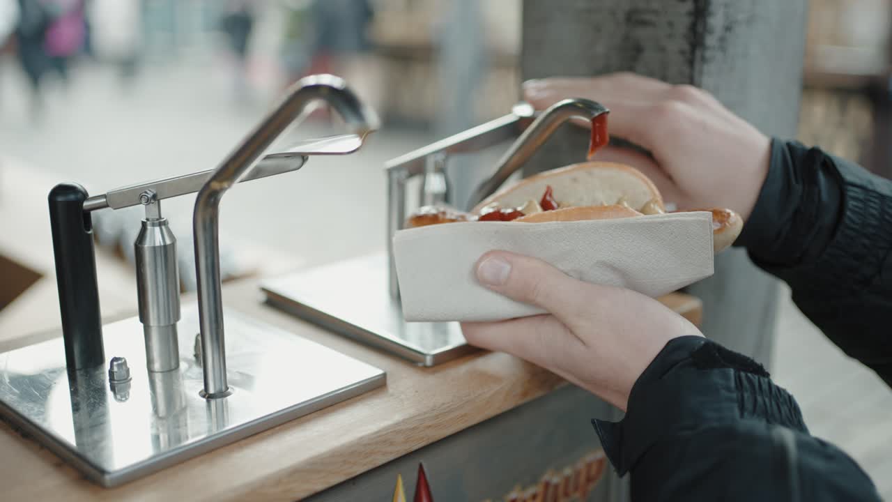 un perrito caliente de salchicha alemana rociado con ketchup y mostaza en un mercado