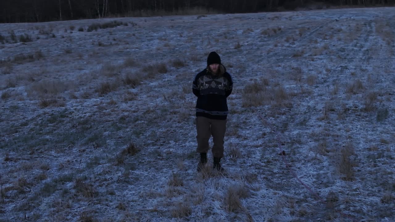 Ensom mand i varmt tøj går på snedækket mark i Indre Fosen, Norge