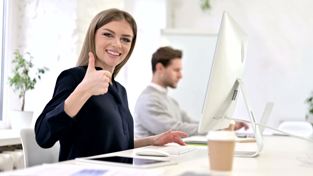 mujer ambiciosa y creativa mostrando el pulgar hacia arriba en la oficina