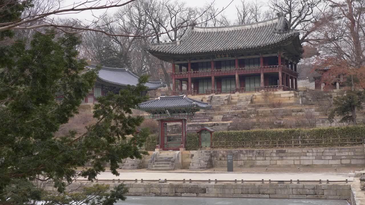 Paesaggio al rallentatore di un monumento storico del tempio circondato da alberi della foresta e lago ghiacciato con santuario del palazzo nel Giardino Segreto di Changdeokgung Jongno Seoul Corea del Sud viaggi e turismo