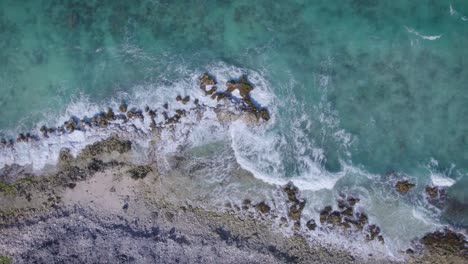 Birdseye-view-of-rocky-coast-in-the-vibrant-blue-Caribbean-Sea,-taken-in-Los-Roques,-Venezuela