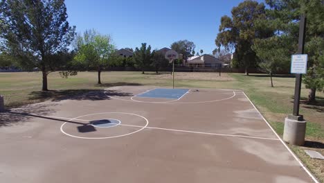 Drone-footage-of-Scottsdale-city-park,-basketball-court-fly-up-to-hoop