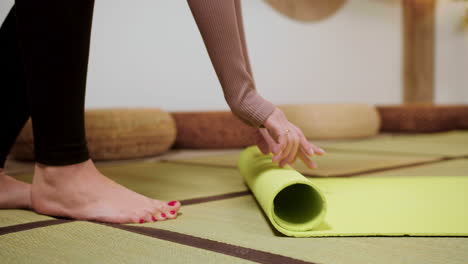 persona poniendo colchoneta de yoga en el suelo