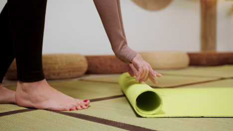 person putting yoga mat on the floor