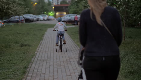 Mujer-Con-Bebé-E-Hijo-Mayor-Caminando-Al-Aire-Libre-Por-La-Noche