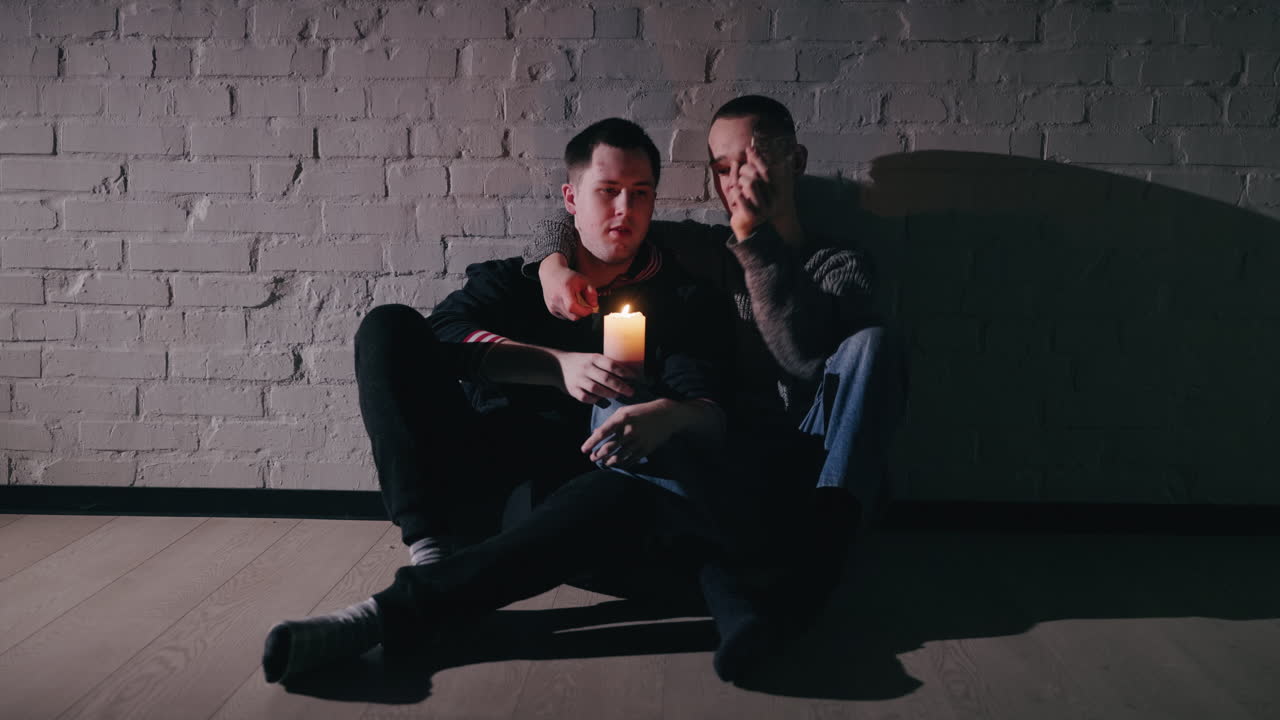 두 남자가 불빛으로 친밀한 순간을 나누고 있습니다.