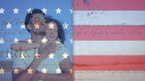 animation of american flag and constitution over happy diverse couple embracing on sunny beach