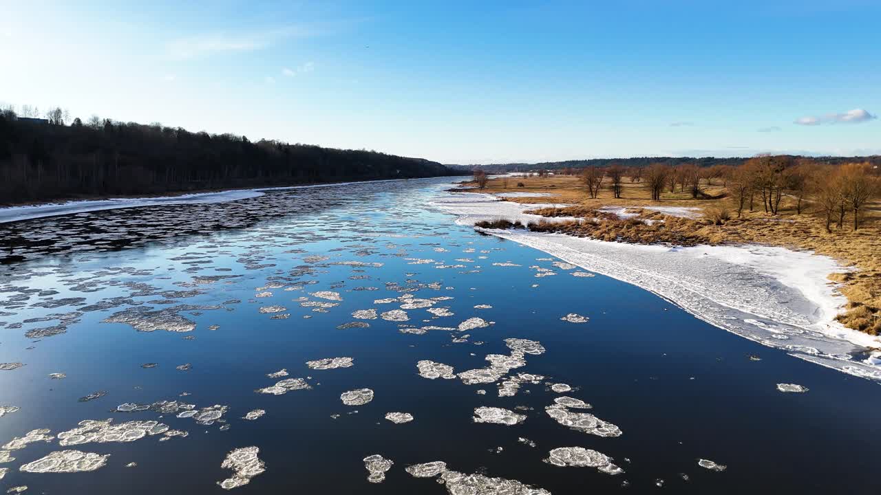 Flowing ice in blue river, aerial drone view