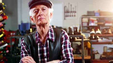 Portrait-of-shoemaker-standing-with-arms-crossed