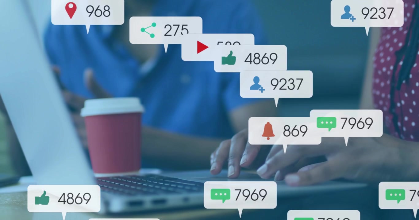 Woman typing laptop spawning social alert bubbles over screen, colleague gesturing, showing ROI