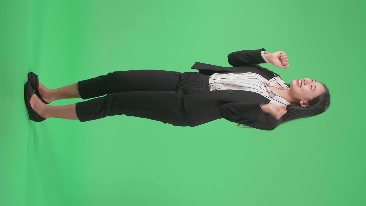Full Side View Body Of A Smiling Asian Business Woman Dancing While Standing On Green Screen Background In The Studio