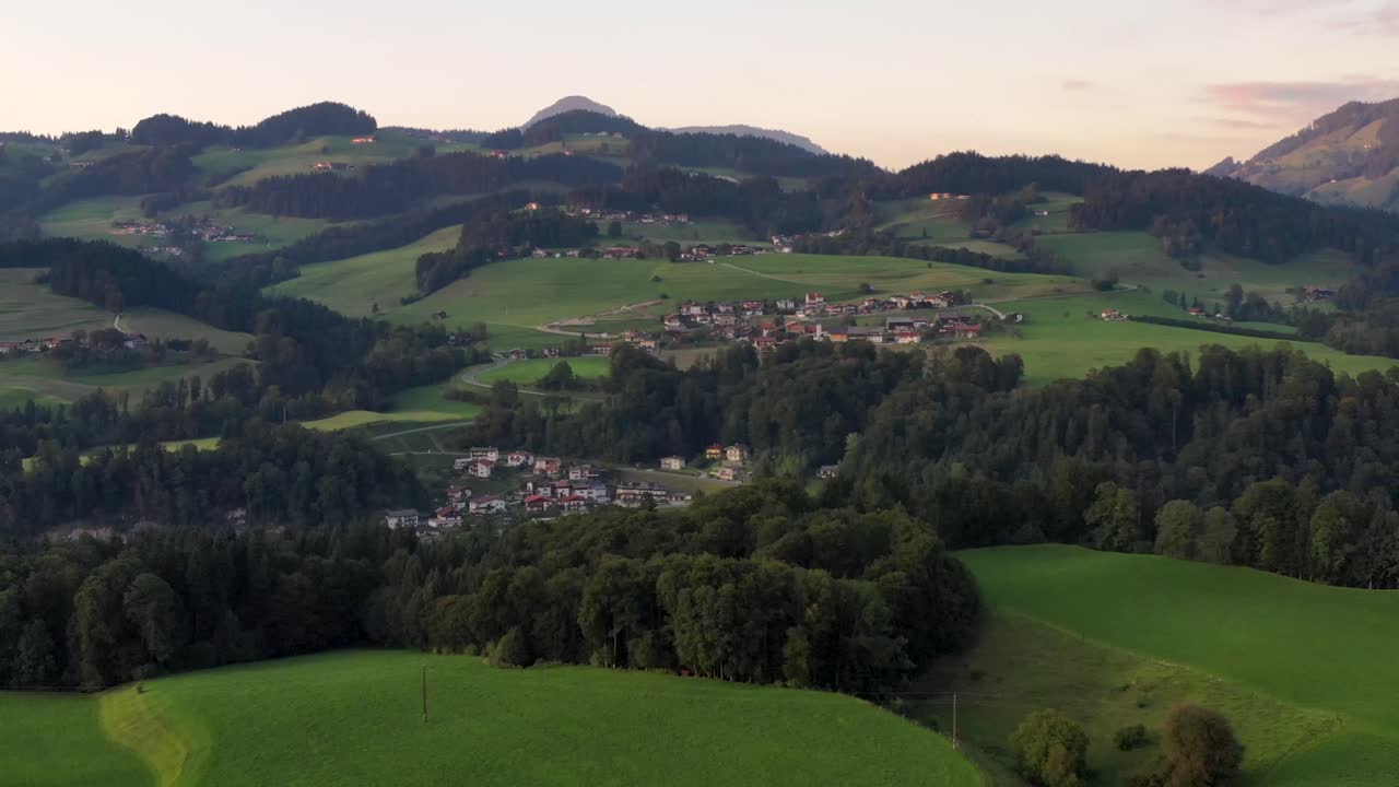 vista de drones de la ciudad de montaña en austria con iglesias, casas coloridas, torre, paisaje de verano al atardecer, alpes austriacos desde arriba, austria, europa