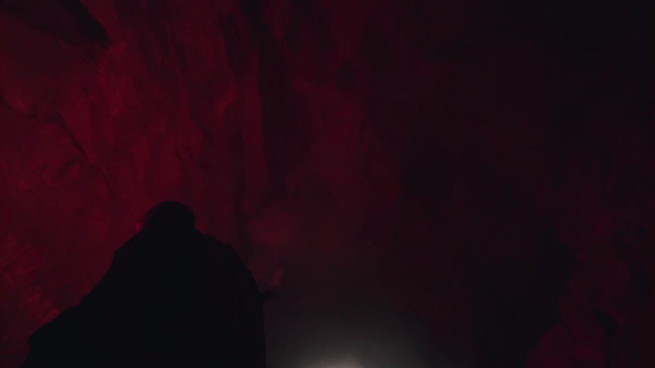 explorando una cueva iluminada en rojo