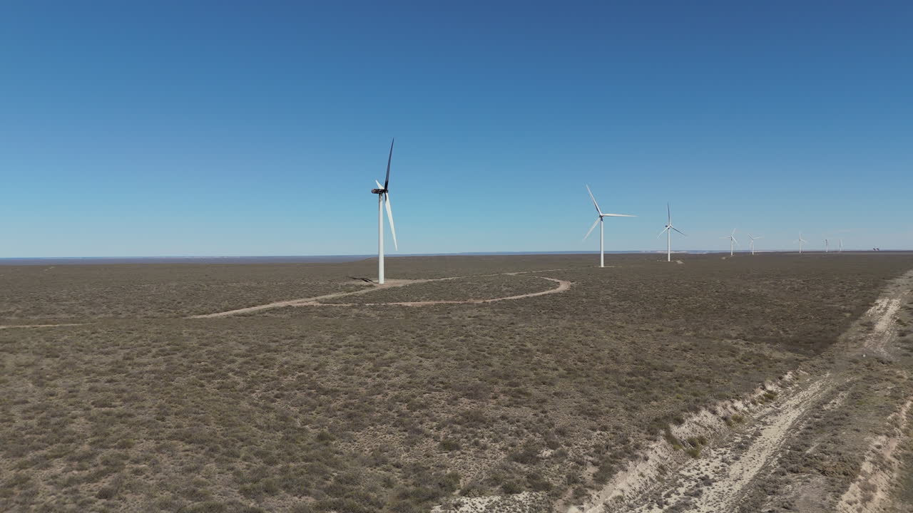 Aerial ascending view of a windmill farm in the Argentinian desert.