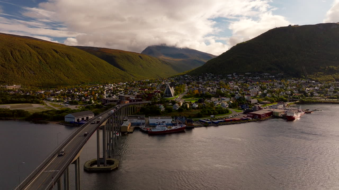 Tromso bridge traffic flow with drone view toward Arctic cathedral and mountains