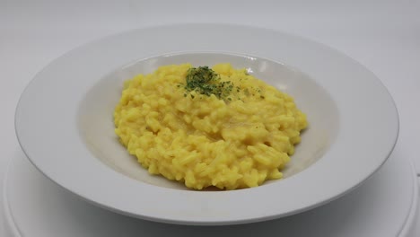 Risotto-Italiano-Con-Azafrán-En-Un-Plato-Blanco