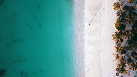 1-Millón-De-$-Vuelo-Aéreo-Vista-De-Pájaro-Toma-De-Drones-De-Personas-Caminando-Con-Largas-Sombras-Sobre-Arena-Blanca-Paraíso-Playa-De-Ensueño-Zanzíbar,-áfrica-Tanzania-2019-Naturaleza-Cinematográfica-1080,-60p-Por-Philipp-Marnitz