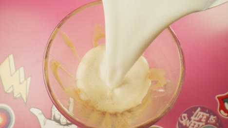 vertiendo leche caliente al vapor sobre helado de vainilla vista superior batido