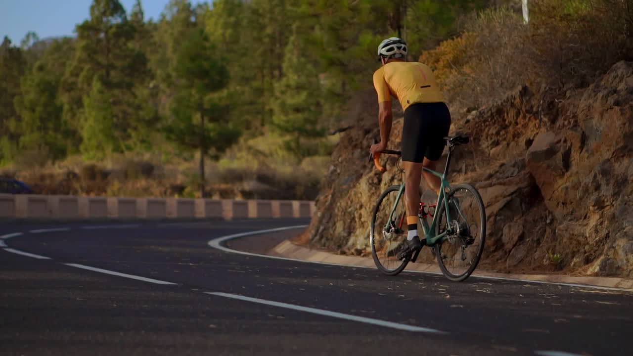 Cyclist athlete conquers a mountain serpentine in slow motion, soaking in the island's panoramic view&mdash;a true embodiment of a healthy lifestyle