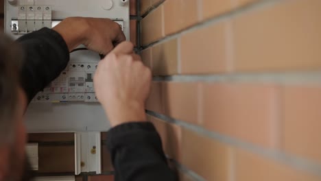 an electrician installing an inverter in a home. the image shows technical skill, modern tools, and attention to safety in electrical work