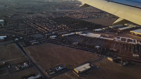 airplane flying above suburbs of las vegas usa before landing on harry reid airport, traffic and buildings pov