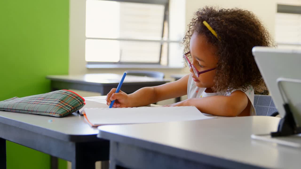 Schoolgirl sitting at desk and studying in classroom 4k