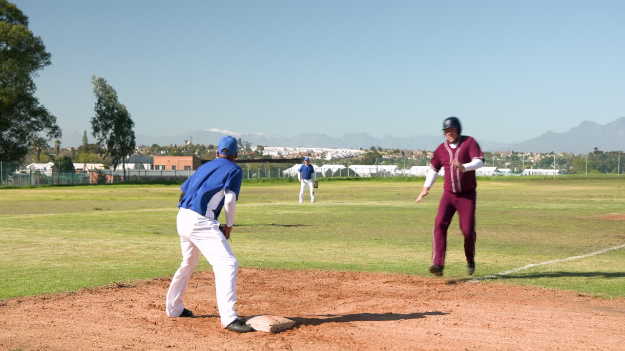Helping teammate stand up, baseball player assisting another on field during game