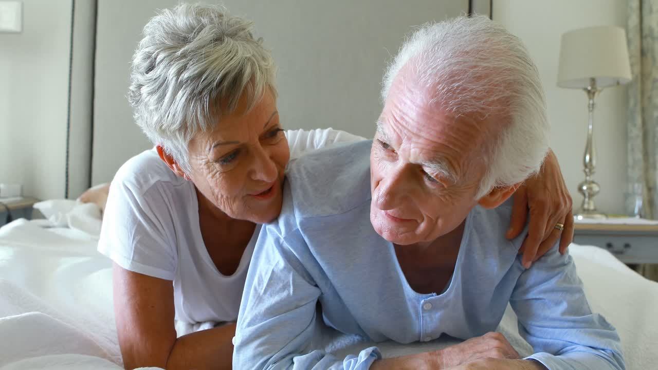 Senior couple interacting with each other on bed in bedroom
