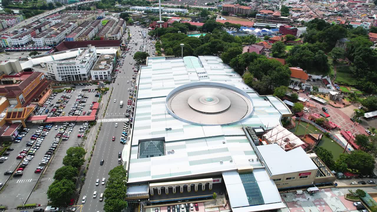 toma aérea giratoria alrededor del ajetreado megamall de melaka con tráfico que pasa