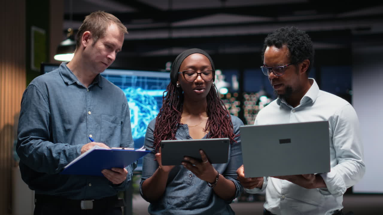 Diverse Business Team Collaborating with Laptop and Tablet in Modern Office