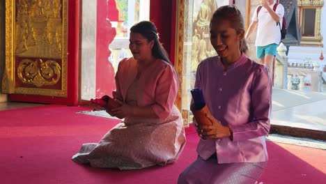 women praying in a thai temple