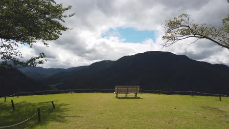 panoramic view of mountains of japan, relaxing single bench green grass overlooking mesmerising sight of nature