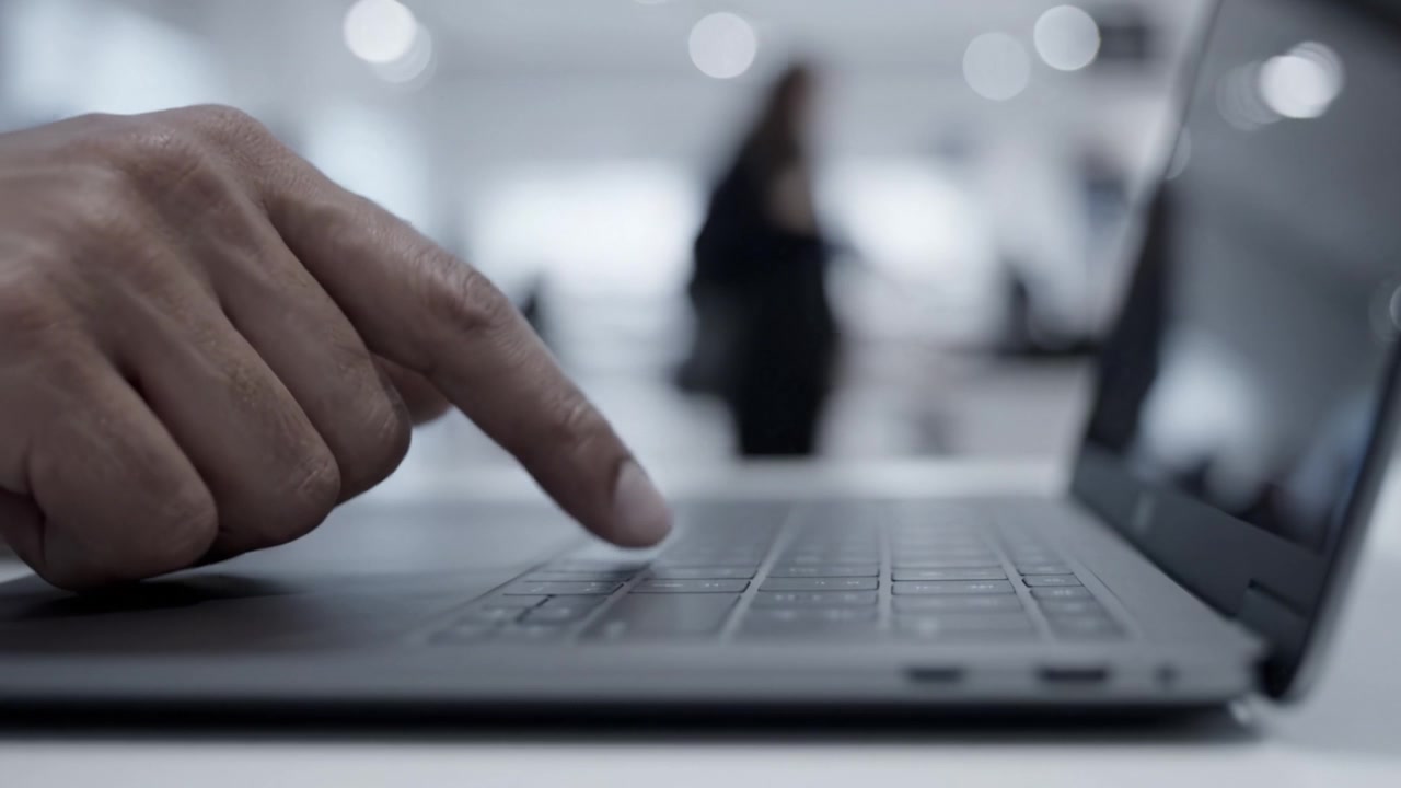 Digitazione concentrata su un laptop: un momento coinvolgente catturato nel tempo, che evidenzia l'interazione tra utente e tecnologia in un ambiente di lavoro moderno.