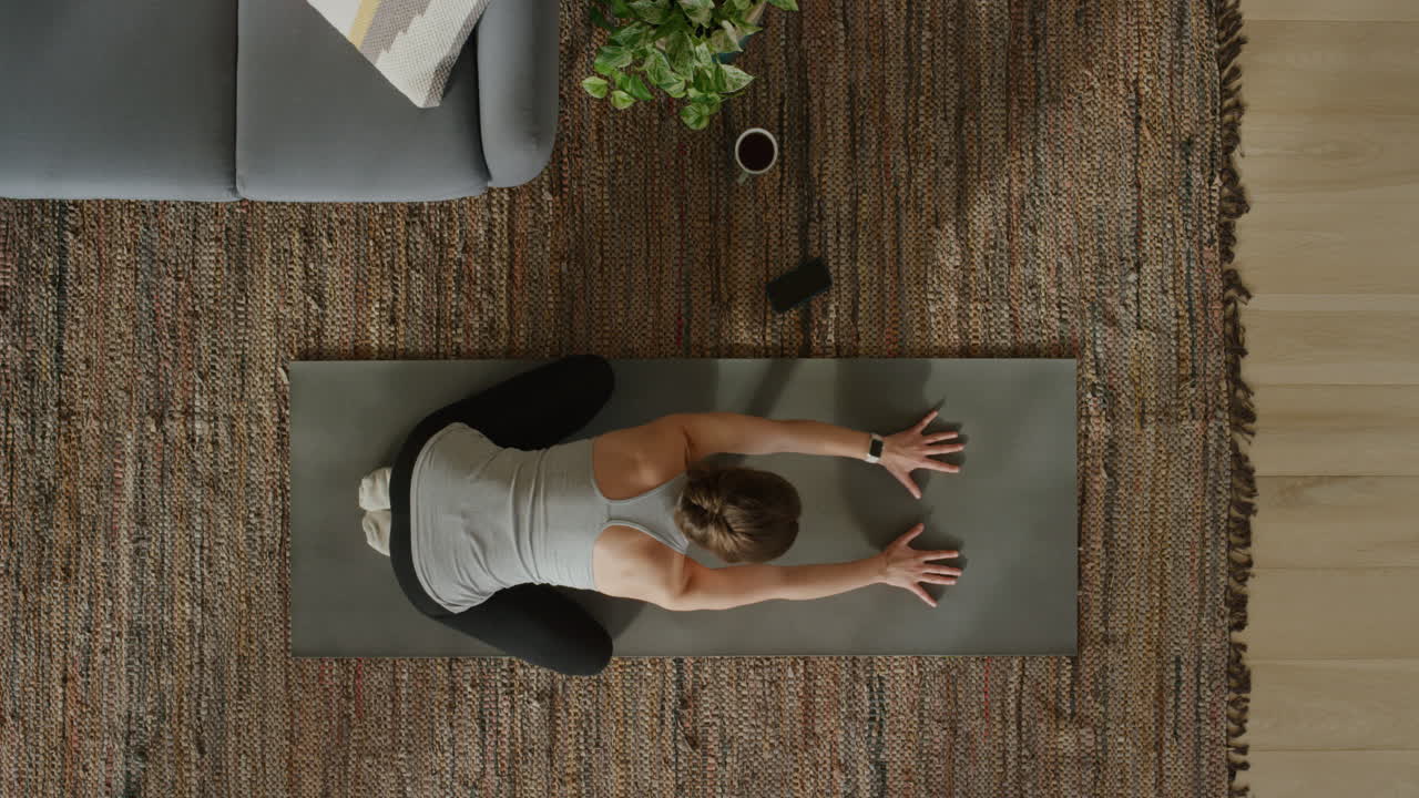 vista superior de una mujer de yoga practicando pose infantil ejercitando un estilo de vida saludable entrenando en casa sobre una colchoneta de ejercicios disfrutando de la meditación de atención plena