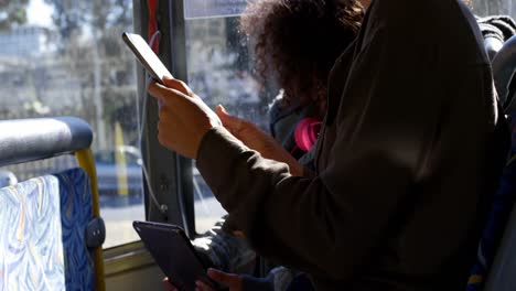 mother and daughter using digital tablet while travelling in bus 4k