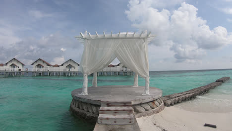 white arch with bungalow and ocean sea background in maldives