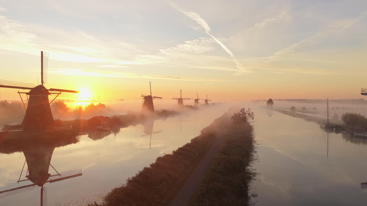 Luftbilde av Kinderdijks tradisjonelle vindmøller i tåkete morgenlys, Nederland