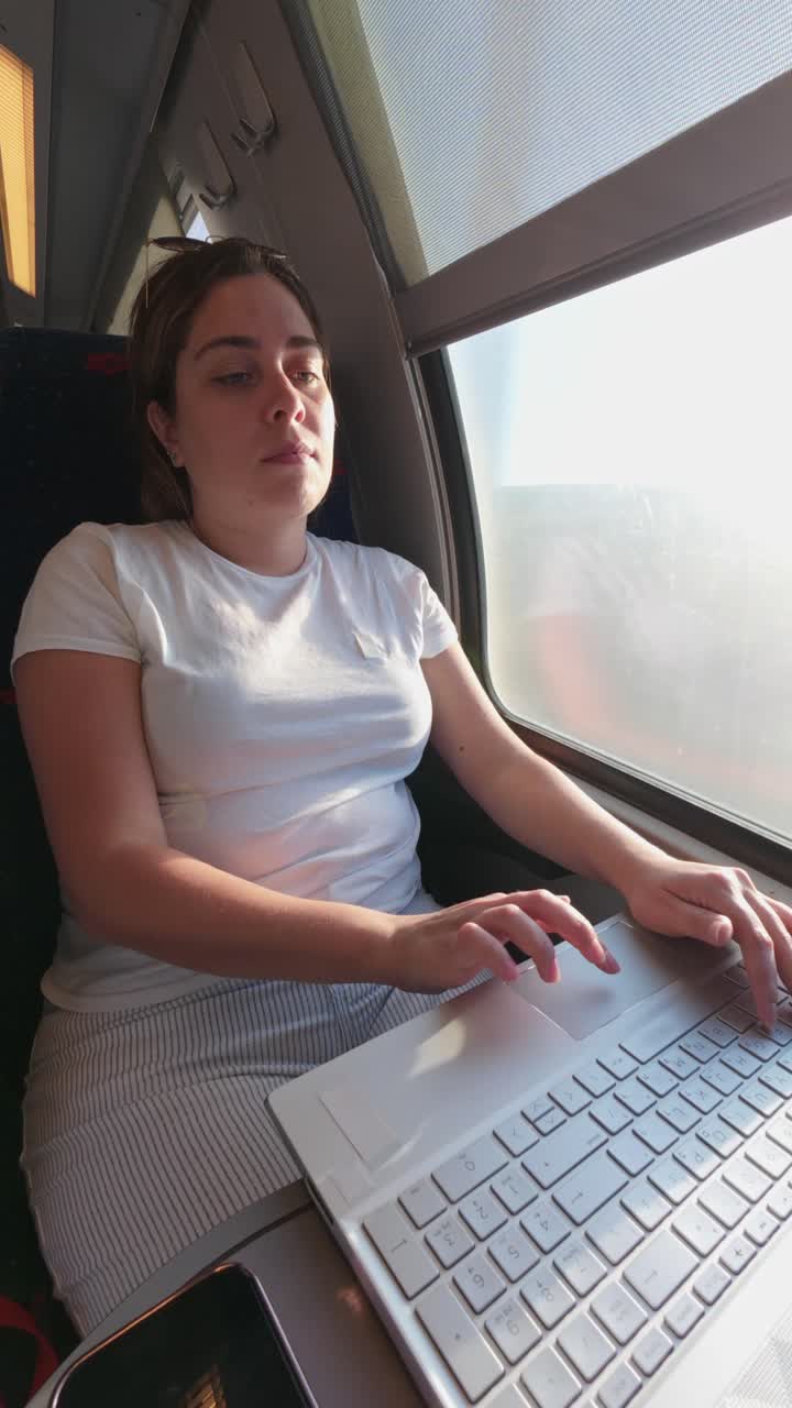 Woman working on laptop during train travel
